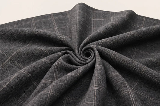 Dark gray plaid fabric draped in a spiral pattern, showing its woven texture and subtle grid lines on a light background.