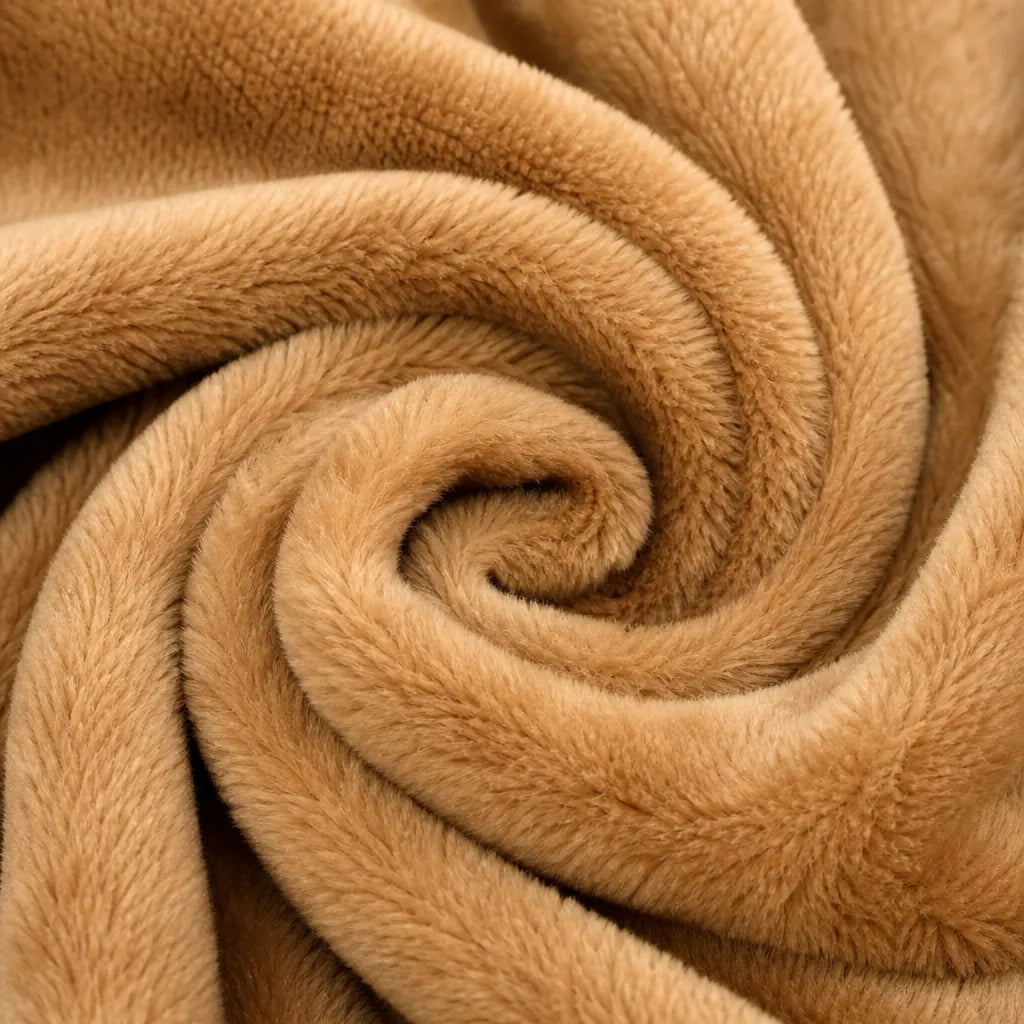 A close-up of plush, soft fabric arranged in a spiral swirl, showing a warm tan or camel color with a fuzzy texture.