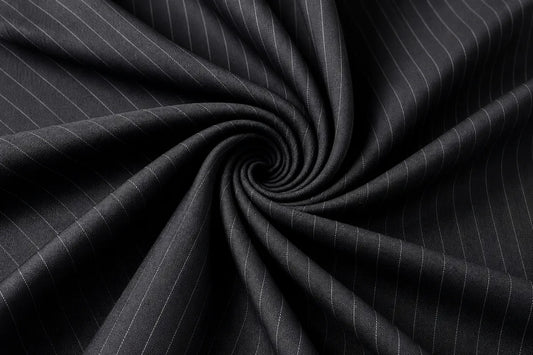 Dark charcoal gray pinstriped fabric arranged in a spiral drape, showing fine white vertical stripes and a smooth texture.