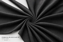 Charcoal black plaid twill fabric draped in a spiral pattern on a white background, with text in the bottom-left corner reading 'CHARCOAL BLACK PLAID TR SUITING FABRIC 320 GSM'.