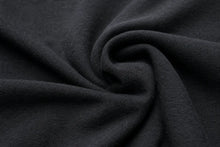 A close-up of dark charcoal gray fabric with a soft, slightly fuzzy texture, arranged in a central swirl to show its drape and texture.