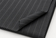 Dark gray pinstriped fabric with fine white vertical lines, folded over to show the zigzag cut edges on a white background.