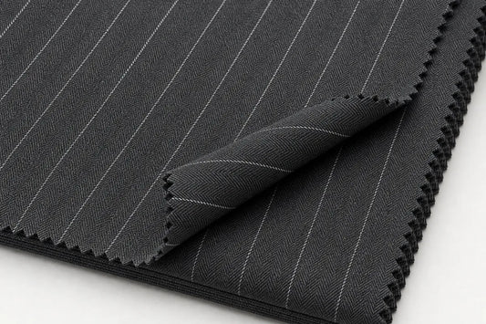 Dark gray pinstriped fabric with fine white vertical lines, folded over to show the zigzag cut edges on a white background.
