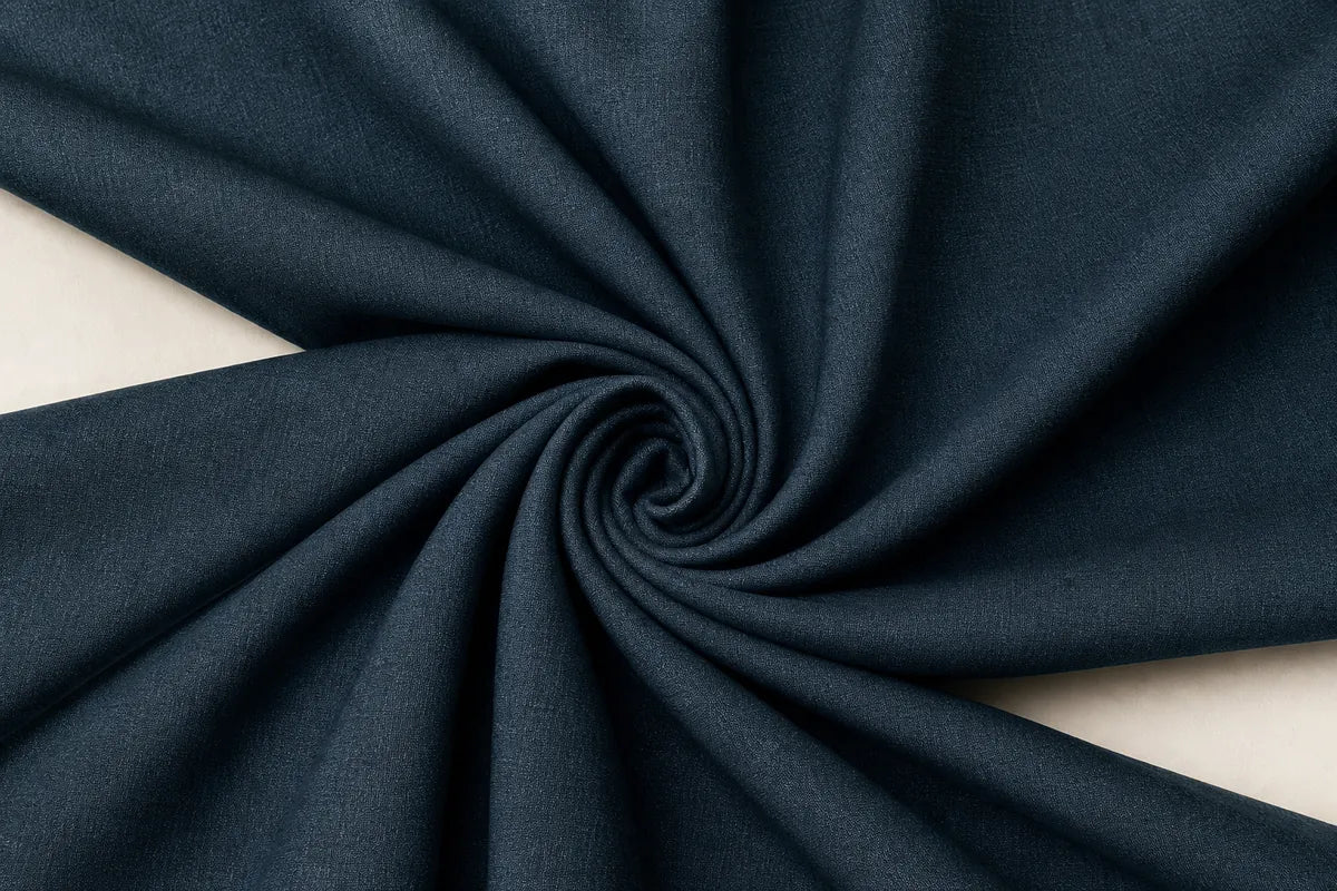 Dark navy blue fabric draped in a spiral pattern against a light beige background.
