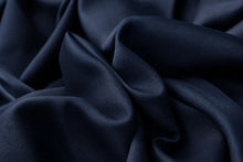 Dark navy blue fabric with a smooth, slightly lustrous texture, shown in soft draped folds.