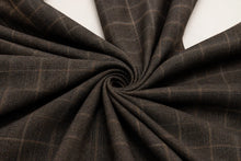 Dark brown fabric with a subtle windowpane plaid pattern, elegantly draped in a spiral swirl against a clean white background.