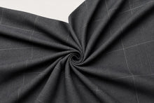 Dark gray plaid fabric draped in a spiral pattern, showing a fine windowpane check design on a light gray background.