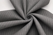 Gray fabric with fine white pinstripes, arranged in a spiral drape on a light gray background.