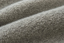 Close-up of a soft, textured gray fabric with a plush, looped surface and gentle folds.