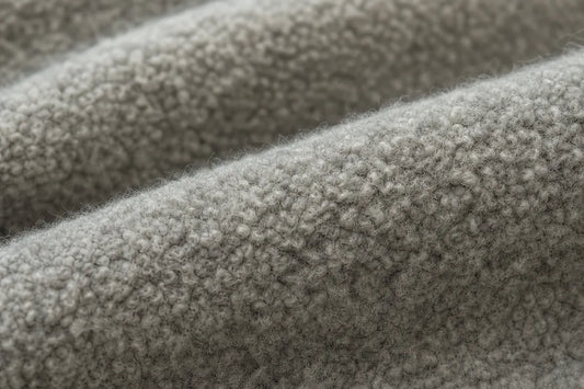 Close-up of a soft, textured gray fabric with a plush, looped surface and gentle folds.