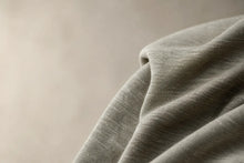 Close-up of textured green fabric on a beige background