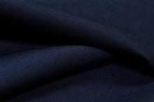 A close-up of dark navy blue fabric with a fine ribbed texture, shown in soft folds.