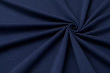 A close-up of dark navy blue fabric arranged in a spiral drape pattern, showing the material texture and color.
