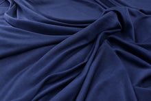 A close-up of draped navy blue fabric with soft folds and a smooth texture.