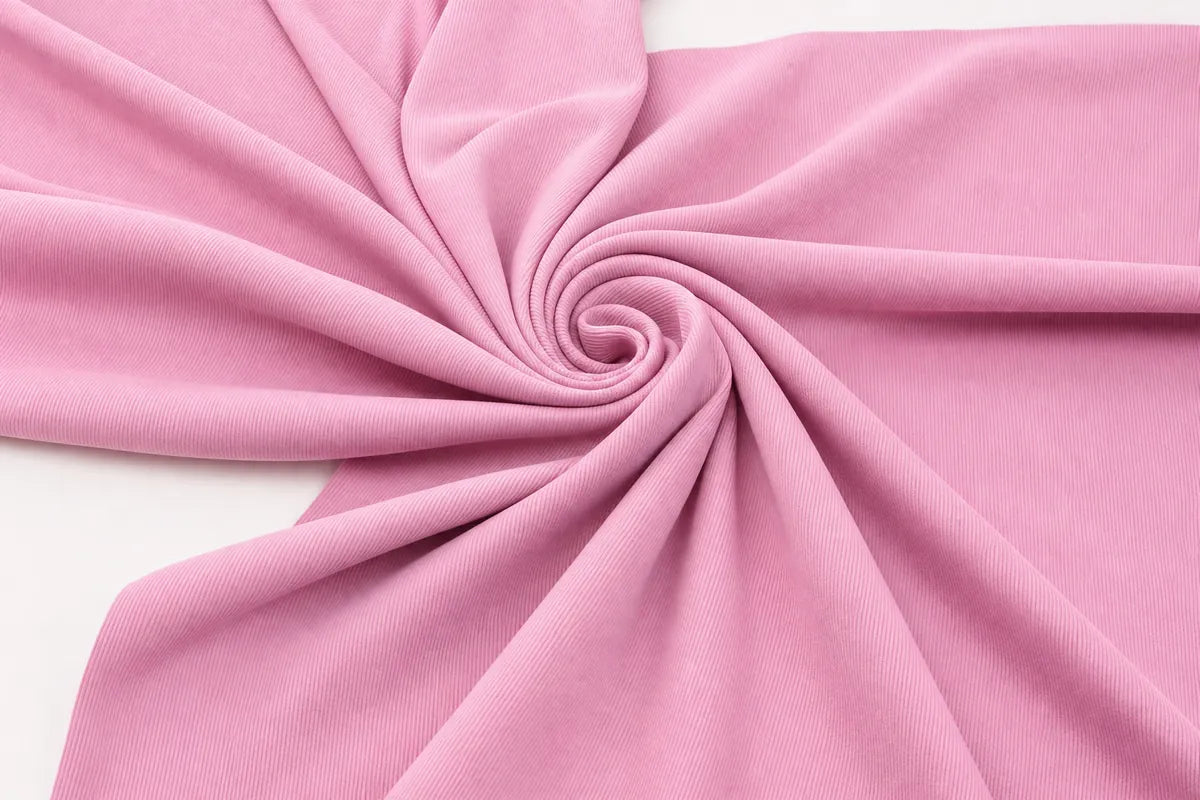 A close-up of draped pink fabric arranged in a spiral pattern on a white background.