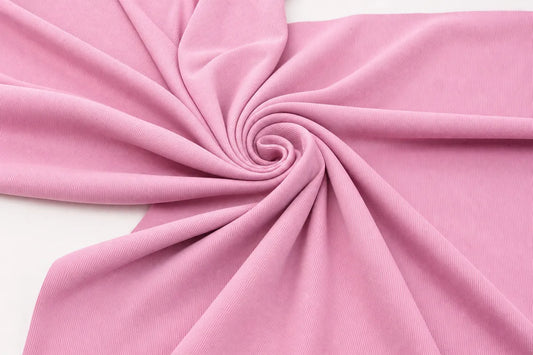 A close-up of draped pink fabric arranged in a spiral pattern on a white background.