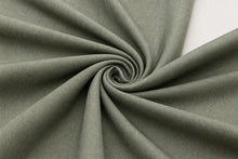 A close-up of olive green fabric arranged in a spiral swirl, showing the material texture and drape against a small white background in the upper right.