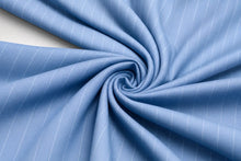 Light blue fabric with thin white pinstripes, arranged in a spiral drape to show texture and pattern.