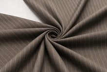 A close-up of draped fabric in a taupe-brown color with thin, light beige pinstripes, arranged in a central spiral fold.