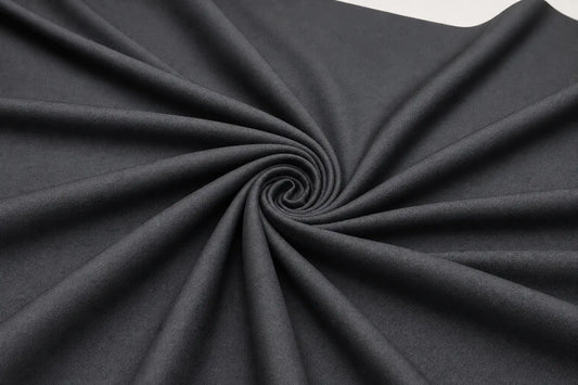 Dark charcoal gray fabric draped in a spiral pattern to show its texture and drape.