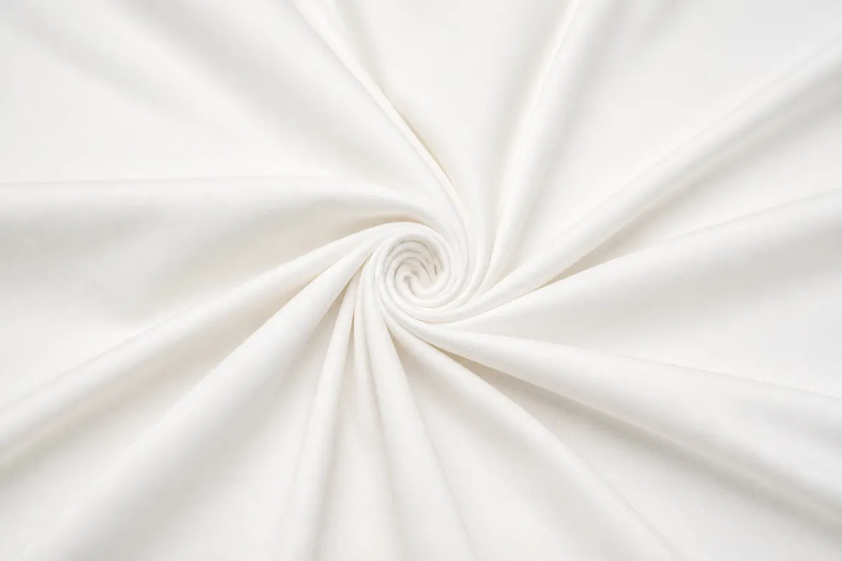 White fabric draped in a spiral pattern, showing a smooth texture and soft folds.