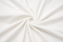 White fabric draped in a spiral pattern, showing a smooth texture and soft folds.