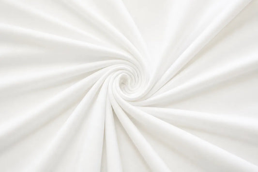 White fabric draped in a spiral swirl pattern, showing soft folds and a smooth texture.